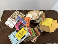 Overhead view of large collection of laminated and paper access passes and credentials spread on table.