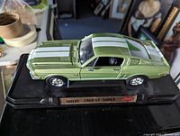 Front and side angle of the green die-cast Shelby 1968 GT-500KR model car on its display stand.