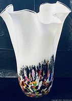 Front view of the white vase with multicolored spotted base and ruffled handkerchief rim.