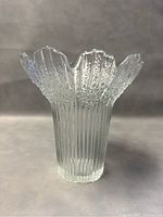 Front view of the clear blown glass vase with ribbed texture and petal-shaped flared top.