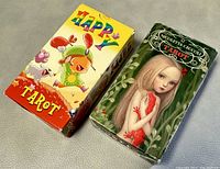 Box photo showing two tarot card decks: Happy Tarot and Nicoletta Ceccoli Tarot.
