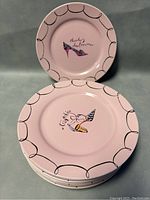 Stack of eight pink Rosanna dessert plates with black scalloped edging and colorful high heel designs