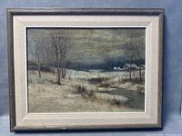 Full front view of framed oil painting depicting a winter landscape with trees and houses under a cloudy sky