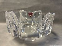 Angled close-up view of Orrefors crystal footed bowl showing clear segmented design and red label.