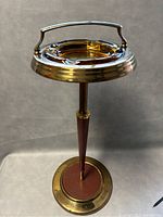 Full view of brass plated ashtray stand with amber glass ashtray in place on top.