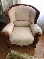 Front view of carved wood frame armchair with floral upholstery