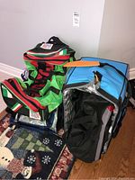 Green and black duffel bag with Italy flag and Italy text, blue insulated bag with partially opened zipper, all on patterned carpet