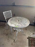 Overview of the metal bistro set showing the table and single chair with distressed paint finish.