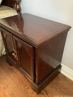 Side view of Strathroy wooden nightstand showing polished dark wood finish and carved detailing on cabinet doors