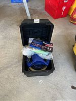 Open black carrying case with blue orbital waxer/polisher inside, attachments and instruction manual included.