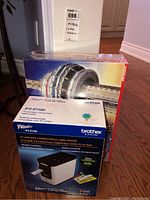 Front view of CN Tower 3D puzzle box and Brother PT-P700 label maker box stacked together.