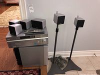 Photo of the receiver, subwoofer, and five cube speakers including two on stands.