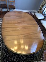 Top view showing wood veneer oval tabletop with scratches and wear.