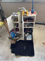 Photo of two white cabinets opened revealing various hand tools including wrenches, pliers, and small hardware inside.