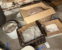 View of different containers with potters' clay stored inside plastic bags and boxes