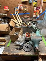 Wide view showing bench vise, wood spindles, casters, sanding and filing attachments, and other miscellaneous tools on workbench