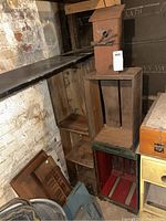 View of stacked wooden crates and the wooden birdhouse on top. Crates show rustic, vintage appearance and wear.