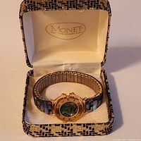 Watch in original Monet box, showing front face and band with abalone inlay.