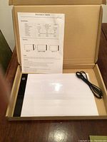 Artist light box with USB cable and instruction sheet in open box.