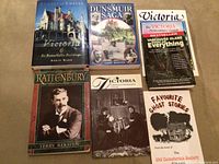 Six books displayed on a carpeted floor showing various Victoria BC related titles including biographies and local histories.