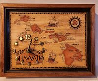 Front view of vintage Hawaii map wall clock in wood frame, showing the detailed illustrated map, gold-tone hour markers, clock hands, and compass rose.
