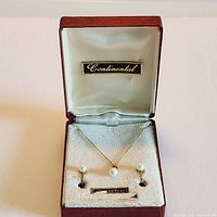 Original red and cream Continental box containing necklace and earrings set with cultured pearls on a gold-tone chain and screw-on backs.