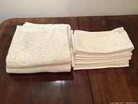 Folded lace tablecloths and stacked square napkins placed on wooden table