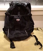 Front view of black Obusforme backpack showing logo and main compartment.