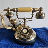 Front view of the vintage rotary phone showing the rotary dial and handset with cream accents.