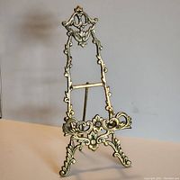 Front view of the solid brass ornate photo or book stand showing detailed floral and scroll designs.