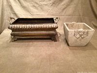 Two garden plant containers placed next to each other on a fabric surface, showing both items in full.