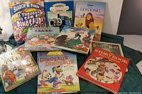 Photo showing 10 children's books with colorful covers including dinosaurs, Thomas the Tank Engine, and Lion King.