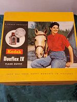 Box lid featuring Kodak Duaflex IV Flash Outfit packaging with image of woman and horse, logo, and vintage branding