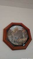 Photo of one framed collector plate featuring a scenic old stone mill with waterwheel surrounded by autumn trees in a wooden octagonal frame.