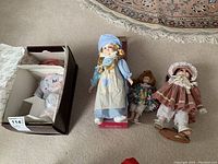 Four dolls including Michael and Yolanda Perfect Babies dolls and two unmarked dolls, three are standing and one remains seated in box.