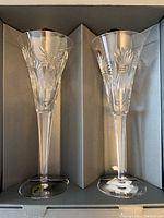 Two crystal champagne toast flutes in packaging, showing cut design and overall condition