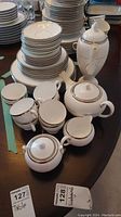Full set including plates, cups, saucers, creamers, sugar bowls, teapot, coffee pot arranged on table