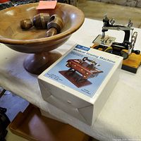 Walnut footed bowl with two wood screw nutcrackers, miniature sewing machine and music box box