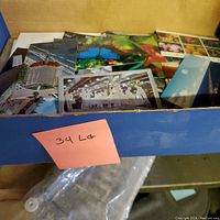 Box of assorted unused travel postcards showing variety of images including buildings and nature scenes