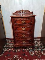 Front view of carved mahogany French style dresser with four drawers, showing decorative brass handles and ornate carvings.
