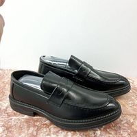 Pair of men's black leather dress shoes, size 9.5, shown from a side angle on a surface.