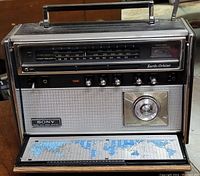 Front view of Sony CRF-5090 Earth-Orbiter 9-Band shortwave and medium wave radio receiver showing frequency display, tuning knob, control knobs, speaker grille, and fold-down world time zone map.