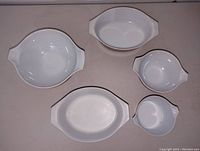 Top view of all 5 dishes showing white and brown pieces with handles and lids