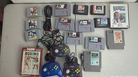 Full lot overview showing Atari 2600 Boxing cartridge, Super Nintendo and Sega Genesis cartridges, and three controllers with cables.