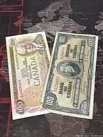 Front side of both banknotes laid on map surface