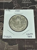 Reverse side of the 1946 Canadian 50 cent coin showing Canadian coat of arms and details about silver content and date.