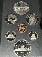 Photo of seven Canadian coins in a black display case, showing front designs and the variety of coins included in the set.