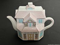 Front-angle view showing building shape, roof tile texture, painted windows, door and Village Tea Room lettering