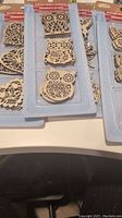 Wooden decorative shapes in packaging, including three owls arranged vertically, with laser-cut details.