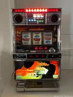 Front view of vintage Takasago Bruce Lee slot machine showing illuminated upper display, three spinning reels, and Bruce Lee graphic on lower panel.